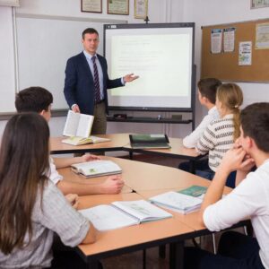 Преподаватель СПО у проектора объясняет материал студентам колледжа